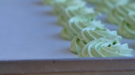Squeeze the cream filling on the green cupcake, closeup.の写真素材
