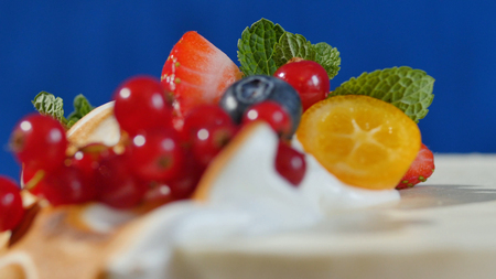 Traditional Christmas fruit cake with white frosting and sugared fruits. Cream cake with kumquat, cranberries, strawberries, closeup.の写真素材