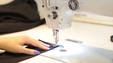 Tailor.Hands notch tailor tailors scissors cloth. Female tailor stitching material at workplace....