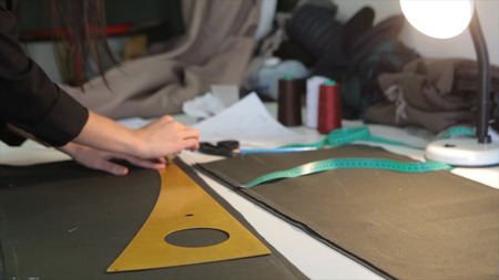 Tailor.Hands notch tailor tailors scissors cloth. Female tailor stitching material at workplace....