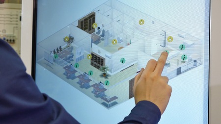 Man works on a touch screen. Young scientist uses a large touch screen to work.の写真素材