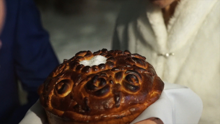 Bread and sault at the Wedding. The groom sprinkles the bread with salt. A symbol of happy and long married life of bride and groom. Russian wediing tradition. Groom and wife eat bread with sauld at he wedding. Weddingの写真素材