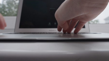 Woman working on laptop near a window. Girls hands working with laptop near windowの写真素材