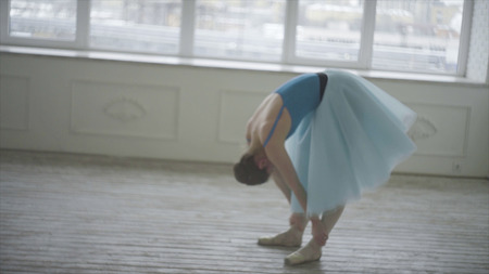 Professional ballet dancer have a rest. Tired ballerina restores breathing and resting. Tired dancer. Female ballerina having a rest after performance or rehearsal.の写真素材