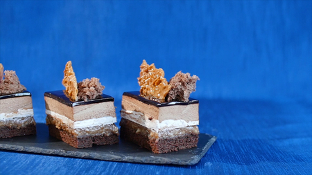 Delicious chocolate cake on plate on table on dark blue background. Dessert - Chocolate Cake