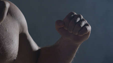 Punches close up in smoke dark background. Muscular kickbox or muay thai fighter punching in smoke.の写真素材