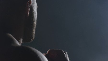 Punches close up in smoke dark background. Muscular kickbox or muay thai fighter punching in smoke.の写真素材