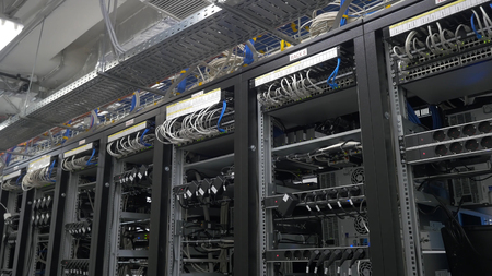 Row of bitcoin miners set up on the wired shelfs. Computer for Bitcoin mining. cables plug to motherboard for mining machine. Cryptocurrency computer with many peripheral slotsの写真素材