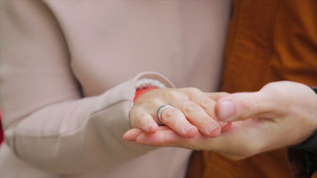 Newly married couple holding hands. Young couple in love walking in the autumn park holding hands. Lovers in the parkの写真素材