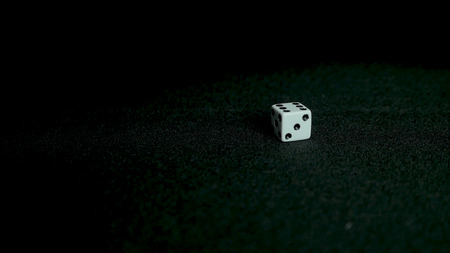 Two standard six-sided pipped dice with rounded corners on black backgroundの写真素材
