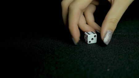 Two standard six-sided pipped dice with rounded corners on black backgroundの写真素材