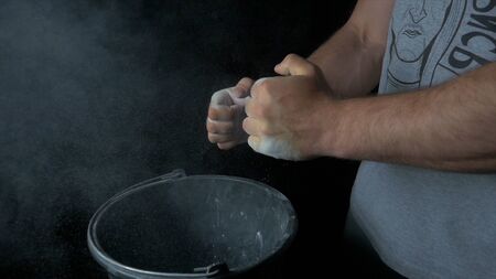 Talc sports. Closeup of a muscular man ready to workout. male powerlifter hand in talc and sports wristbands preparing to bench press. Hands in chalk. male powerlifter hand in talc and sports wristbands preparing to bench pressの写真素材