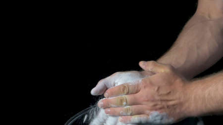 Talc sports. Closeup of a muscular man ready to workout. male powerlifter hand in talc and sports wristbands preparing to bench press. Hands in chalk. male powerlifter hand in talc and sports wristbands preparing to bench pressの写真素材