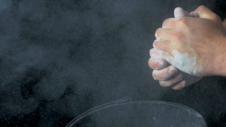 Talc sports. Closeup of a muscular man ready to workout. male powerlifter hand in talc and sports wristbands preparing to bench press. Hands in chalk. male powerlifter hand in talc and sports wristbands preparing to bench pressの写真素材