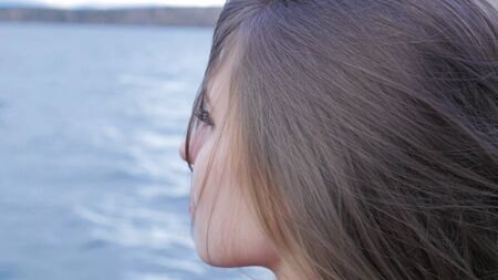Closeup of beautiful girl at lake background. exy female model in trendy sun glasses a background of lake. Relaxing young woman in nature 4Kの写真素材