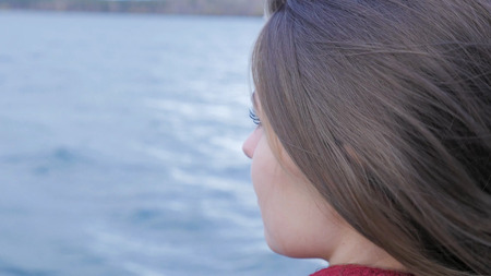Closeup of beautiful girl at lake background. exy female model in trendy sun glasses a background of lake. Relaxing young woman in nature 4Kの写真素材
