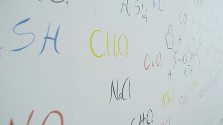 Colorful formulas of the chemical elements on white wall. Chemical formulas written on white chalkboard background. Chemical theme 4Kの写真素材