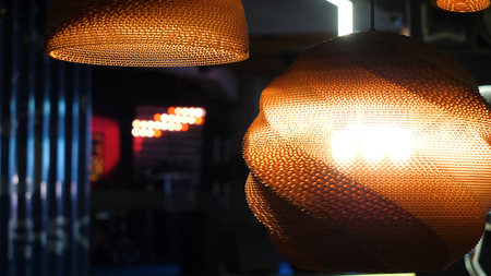 Warm lighting coming out from beautiful lamps while taking a hot cup of coffee in a trendy cafe with nice environmentの写真素材