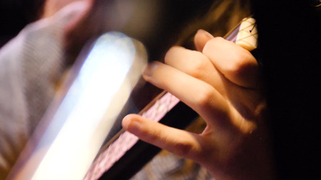 Closeup beautiful acoustic guitar being played by woman sitting down, musician concept. Woman playing the guitar closeup.の写真素材