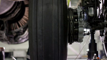 Calm workers controlling aircraft machine and chassis. Aircraft maintenance mechanic inspects plane chassis. Installing new chassis on a plane. Engineer checks chassis. Airport worker mechanicの写真素材