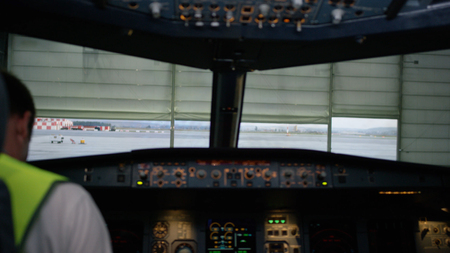 A pilot checking instruments in a plane cockpit. Rear view of pilot operating controls of corporate...