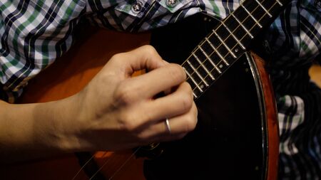 Girl is playing a balalaika, close-up. Folk musical instrument balalaika. Game is on the strings pの写真素材