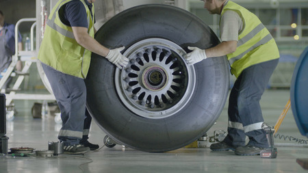 Yekaterinburg, Russia - August 2017: Passenger airplane maintenance personnel working on aircraft main landing gear repair. Engine and chassis of the passenger airplane under heavy maintenanceのeditorial素材