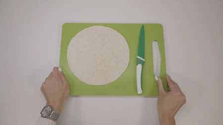 Womans hands cut the rolled dough by knife. Protection Symbol, heat comfortの写真素材