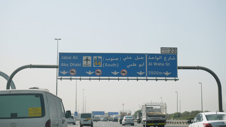 United Arab Emirates, Dubai - October 2017: Man traveling by car in Dubai with a view of the car. View from the interior of the car on the streets of Dubai, the man behind the wheel of a car on a hot dayのeditorial素材