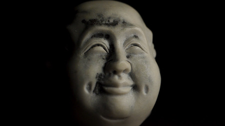 Spiritual enlightenment. Head statue with an emotion happiness. Museum quality statuette against black background. Statuette of a face with an emotion on black background.の写真素材