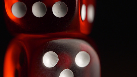 Red dices on black background. Red dice standing on each other, macro on black background.の写真素材