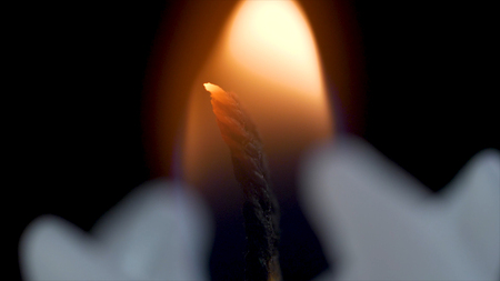 White long candle on black background. Single candle flame light .Long flame , old candle .White candle , black background. White glossy cylinder unlighted isolated on a dark background.の写真素材