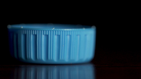 Blue plastic bottle cap isolated on black background. Bottle top. Bottled water isolated over a black background.の写真素材