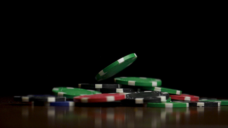 Falling poker chips isolated on black background. Falling poker chips isolated on black background. Colorful poker chips falling at the table on black background. Playing chips flying at the black background.の写真素材
