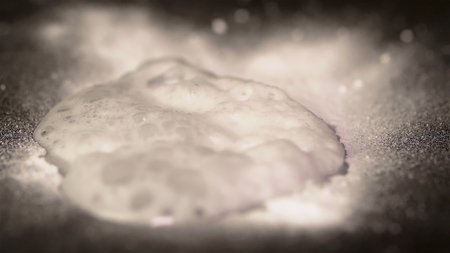 White powder, isolated on black background. White powder reacts with liquid. White powder similar to...