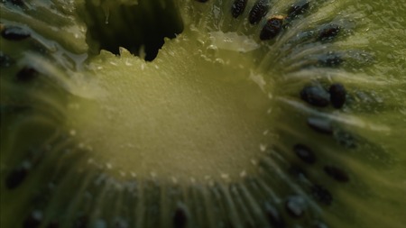 Kiwi fruit slice in extreme close up stock footage. A slice of Kiwi fruit in macro close up with a sliding camera move pの写真素材