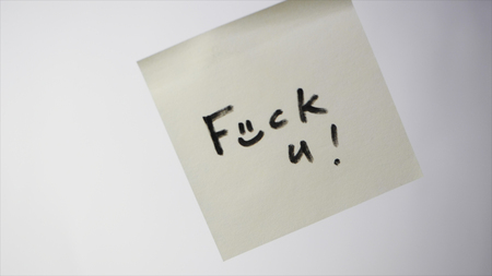 Sticker with the words - fuck you. Inscription FUCK YOU on the sticker. Note FUCK YOU on a piece of...