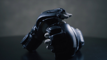 Fist black gloves for martial arts , mma. Pair of boxing gloves on a desk. Concept image, the idea of brutal competitionの写真素材