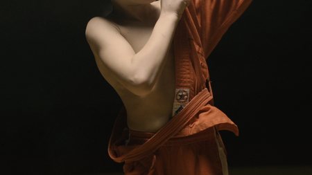 Sportsman boy in a red kimono for judo. Boy puts on a red kimono in preparation for training or sparringの写真素材