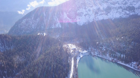 Panoramic view of beautiful white winter wonderland scenery with snowy mountain summits. Clip. Crystal clear mountain lake on a cold sunny day with blue sky and clouds.の写真素材