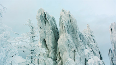 Snowy Rock in the forest. Video. snowy rocks in the mountains with clear sky. Snowy mountain with folding rock layersの写真素材