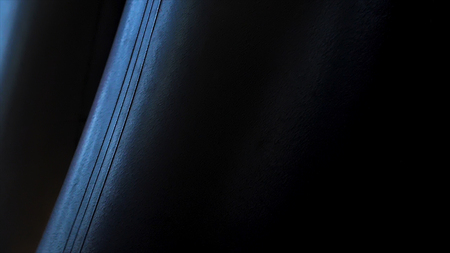 Close-up hand of boxer at the moment of impact on punching bag over black background. Close up of boxing equipment at sport room. Boxing punch close upの写真素材
