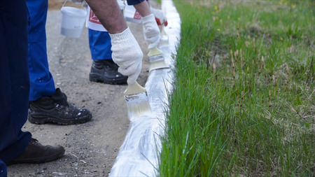 People working with Hand wearing white gloves and painting with a paint brush on borders. Clip. Workers in form painted.の写真素材