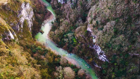 Mountain river flowing landscape. Clip. Aerial beautiful mountain stream, river surrounded by green trees with crystal clear waters winding through the mountainsの写真素材