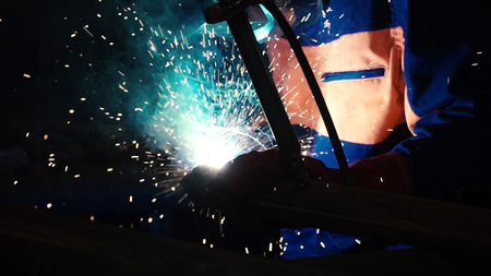 Worker welding construction by MIG welding. Clip. Worker welding the steel part by manual.