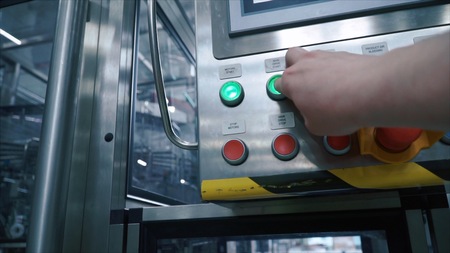 Factory worker presses the button on the control point and starts conveyor of production line.
