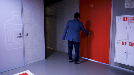 Businessman walking in the hall entrance. Businessman walks into the office.