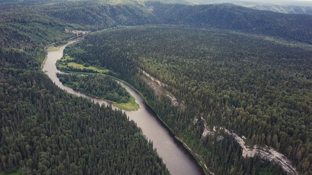 Aerial view of forest river during summer. Clip. Aerial view of woodlands with river in the summer during a flight.の写真素材