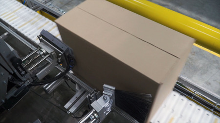 Cardboard boxes on conveyor belt in factory. Clip. Production line on which the boxes move.の写真素材