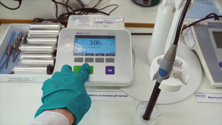 First-person view of staff working in a laboratory. Clip. Young chemical technician checking liquid...
